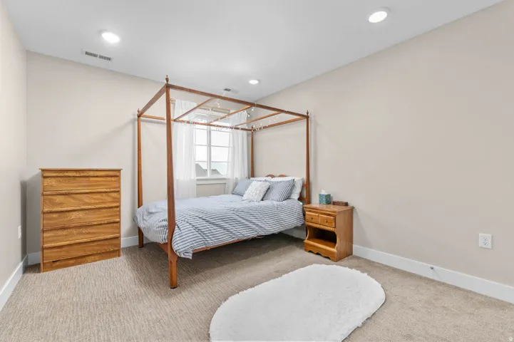Bedroom featuring neutral-toned walls, recessed lighting, and light-colored carpet flooring