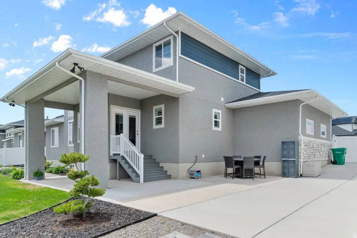 Contemporary two-story residence featuring a stucco exterior with blue horizontal siding accents