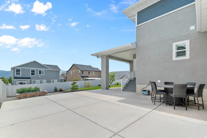 Spacious concrete patio with an attached covered porch and exterior stairs