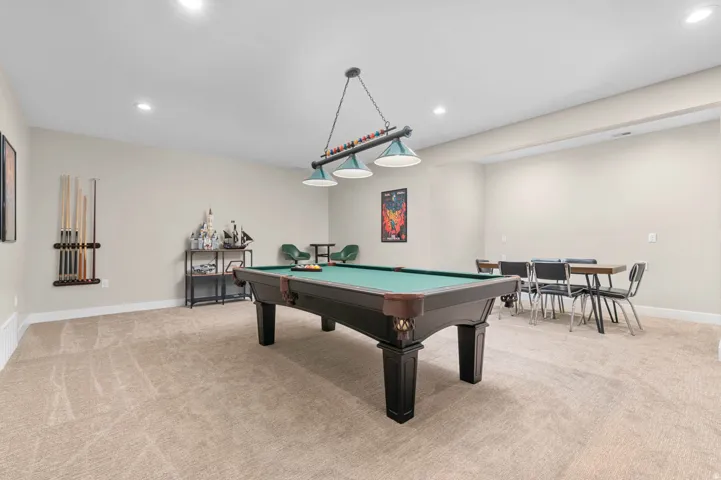 Spacious recreation room featuring neutral carpeting and light-toned walls