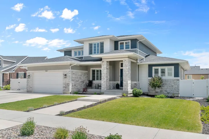 Modern transitional exterior with multi-level rooflines, a two-car garage, and stone veneer accents