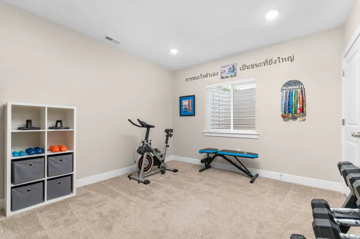 Carpeted room with recessed lighting and a window featuring horizontal blinds