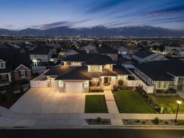 Contemporary residence with a dark shingled roof, stone facade accents, and a concrete driveway