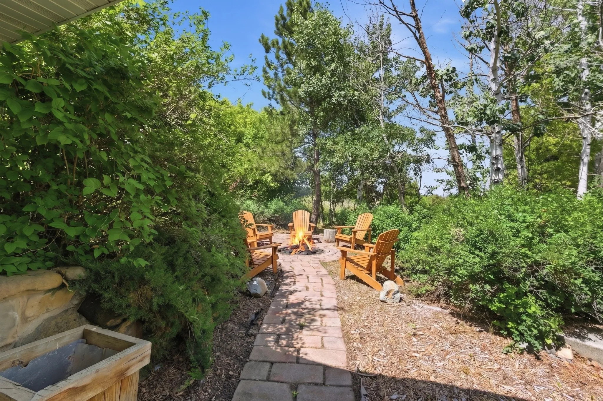 Brick paver pathway leading to a dedicated fire pit area