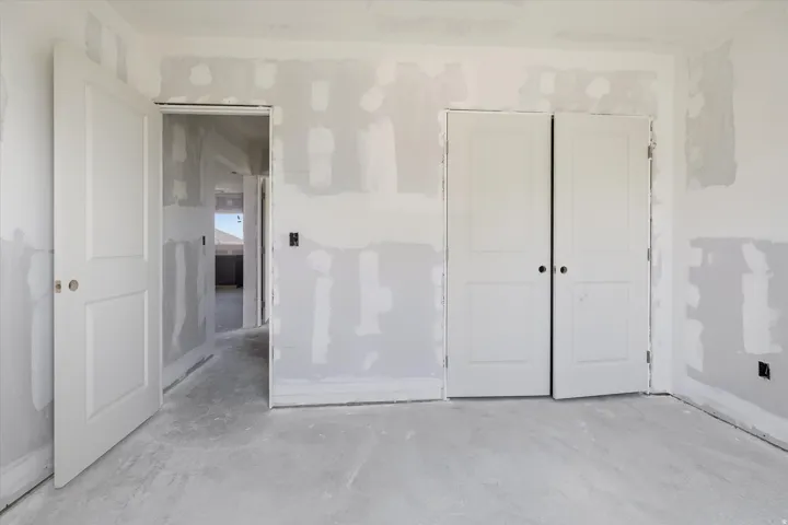 Unfinished interior space featuring drywall installation and two-panel interior doors