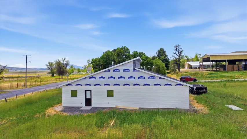 New construction featuring white horizontal siding and a dark entry door