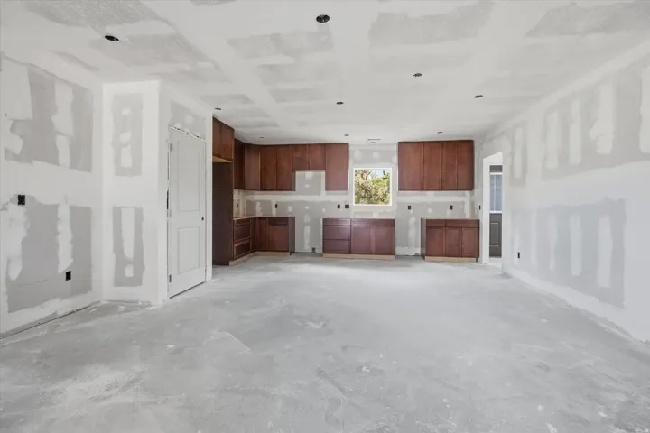 Kitchen area featuring rich wood cabinetry, a window overlooking exterior greenery, and recessed ceiling lighting