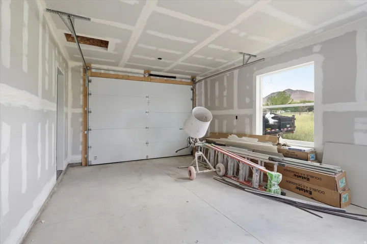 Garage interior featuring a sectional overhead door, finished concrete flooring, and a large window