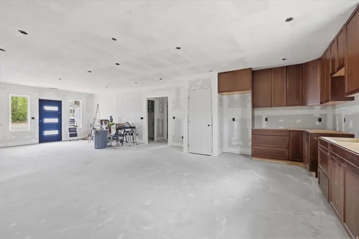 Open-concept space featuring recessed lighting and a blue entryway door with frosted glass inserts