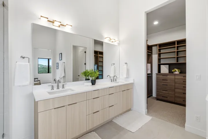 Dual vanity with light wood-finish cabinetry and white countertops