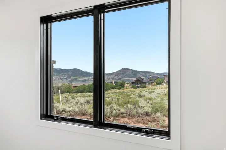 Large window with black frames showcasing expansive mountain scenery