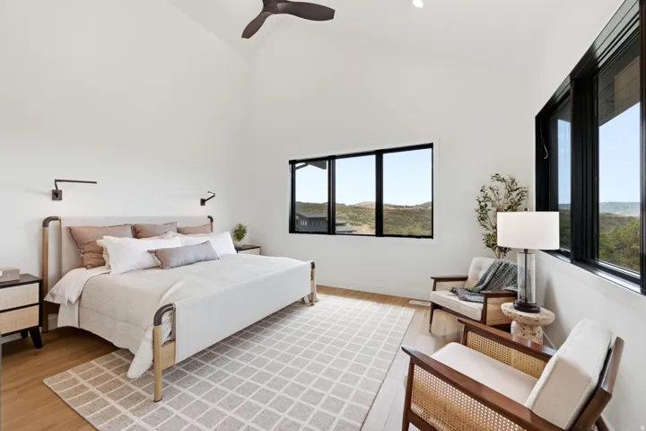Vaulted ceiling with a ceiling fan, recessed lighting, and wall-mounted sconces