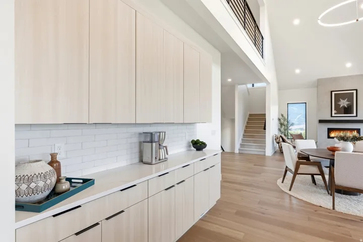 Kitchenette featuring light wood-finish cabinetry, white subway tile backsplash, and light-toned countertops