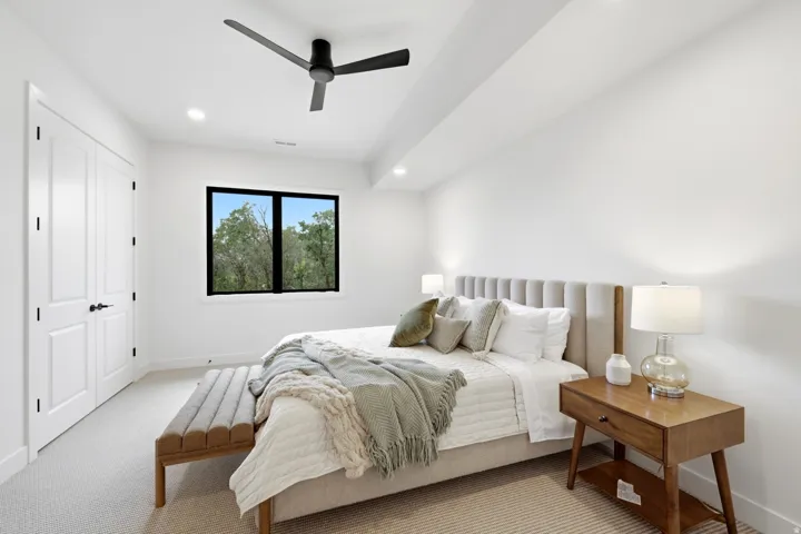 Bedroom featuring white walls and trim, black-framed window, recessed lighting, and a contemporary ceiling fan