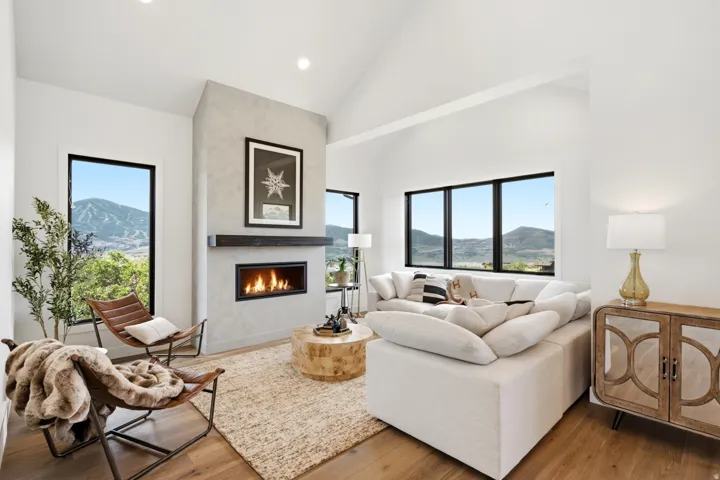 Spacious living area featuring a linear fireplace set into a textured concrete-finish accent wall