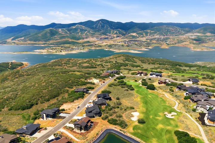 Expansive landscape featuring a large body of water, distant mountains, and a golf course