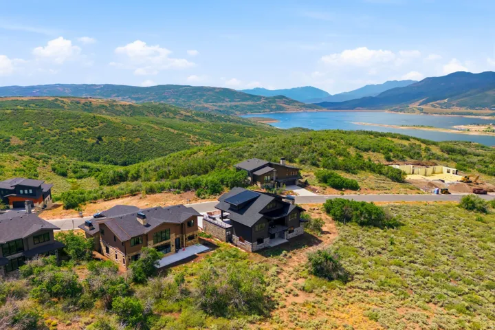Contemporary residences situated on hillside lots, featuring multi-level designs and dark-toned exteriors