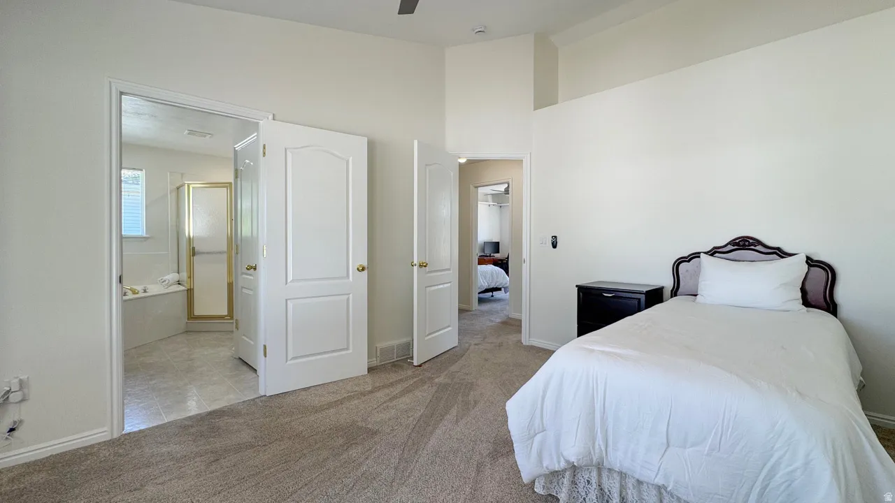 Carpeted interior space with a vaulted ceiling and white walls