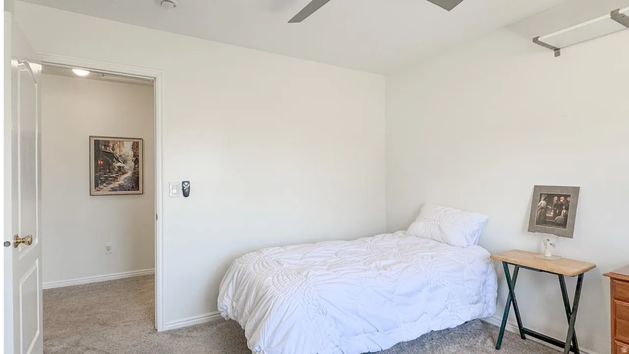 Spacious room featuring neutral paint, carpeted flooring, and a ceiling fan