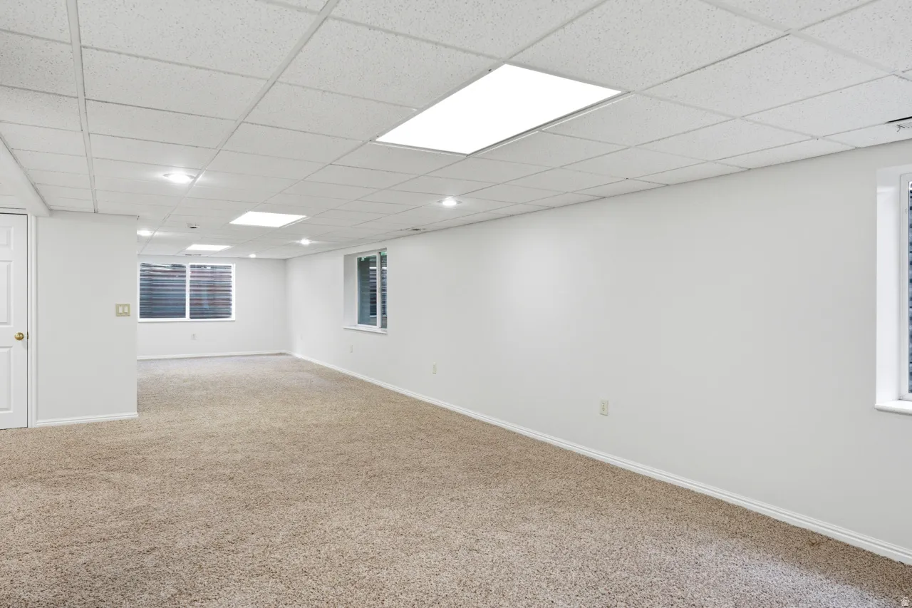 Expansive interior space featuring light beige carpet flooring and white walls