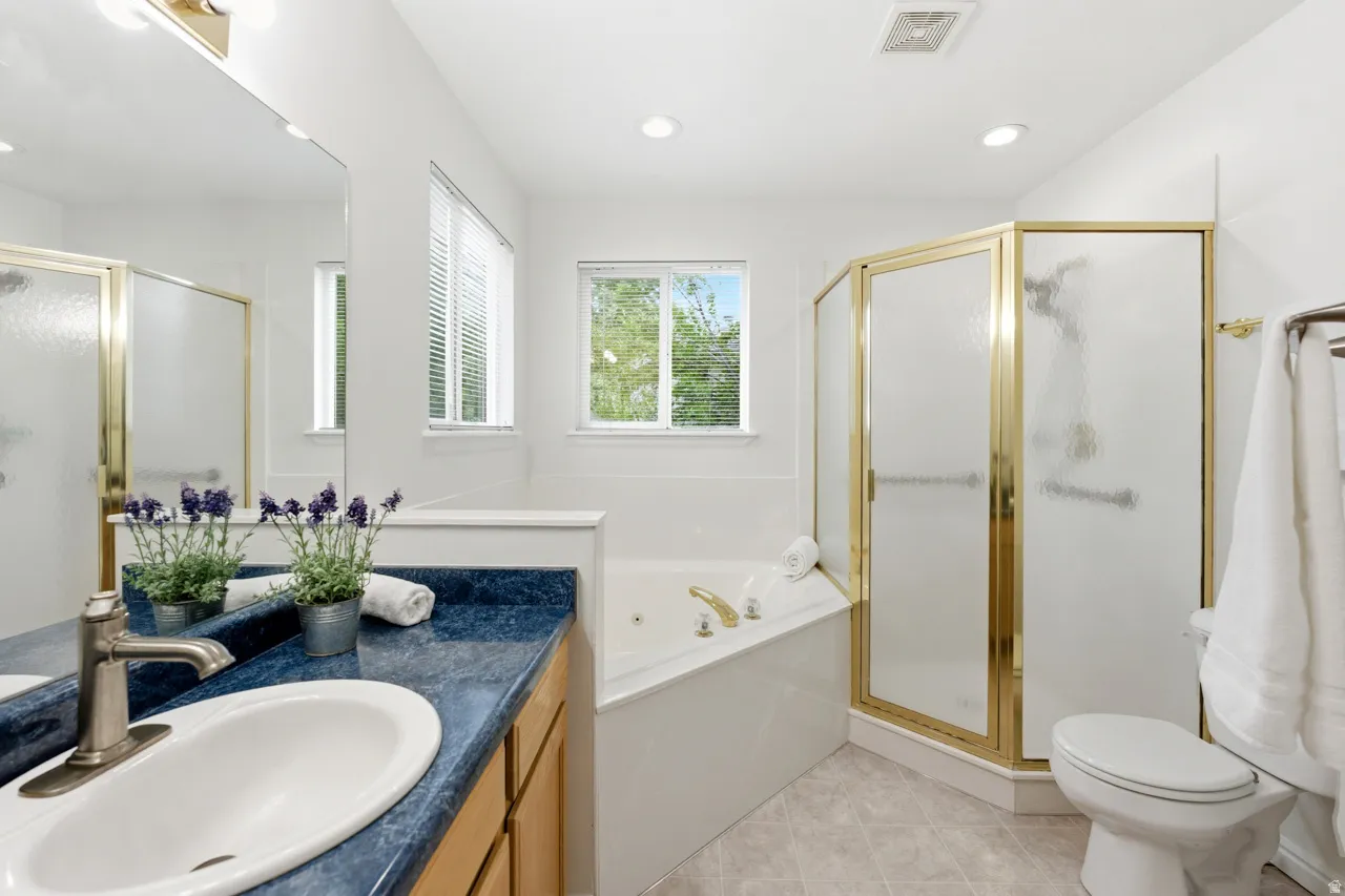 Bathroom featuring a single vanity with a blue countertop, an undermount sink, and a brushed nickel faucet