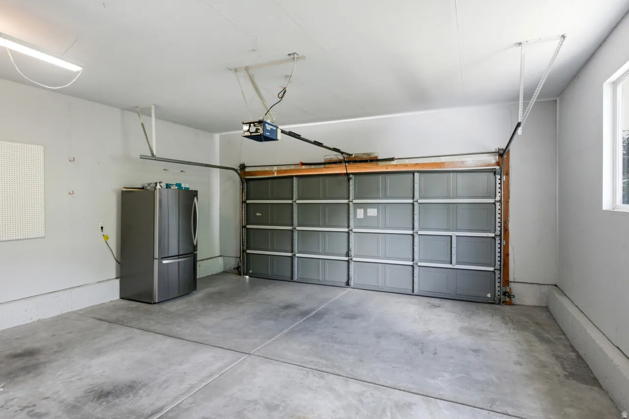 Attached garage with a gray sectional door and automatic opener