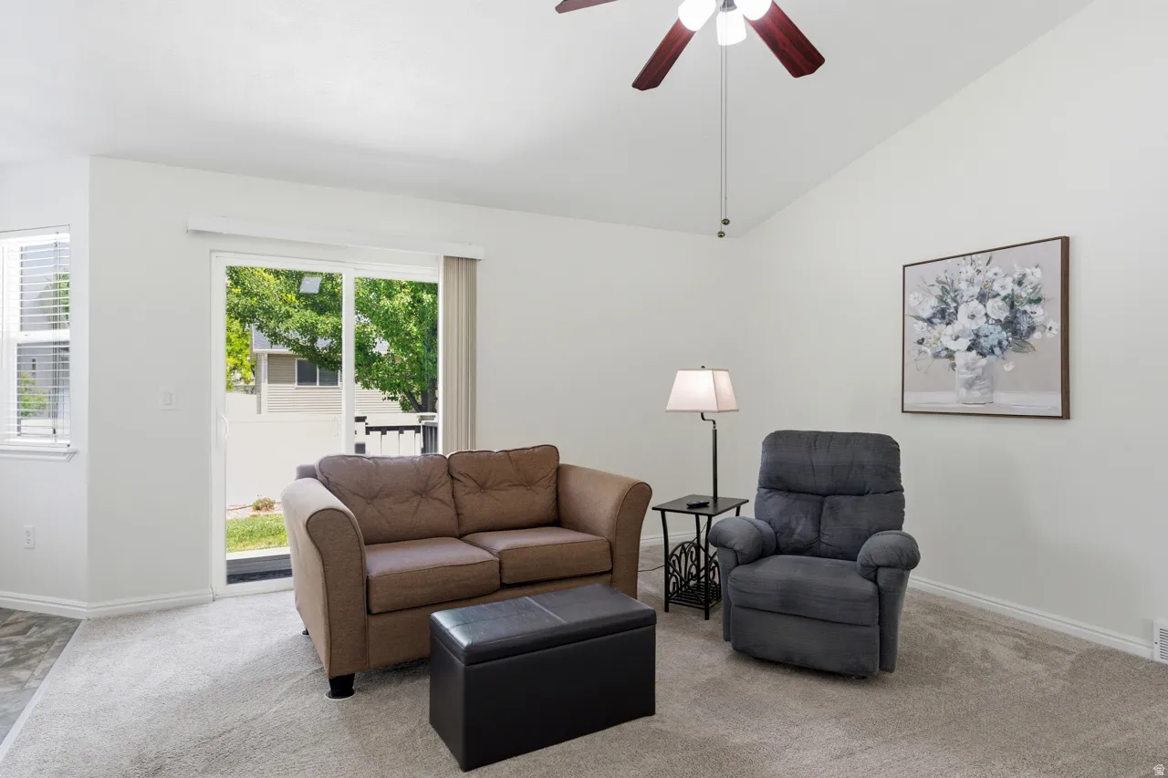 Living area featuring a vaulted ceiling and a ceiling fan