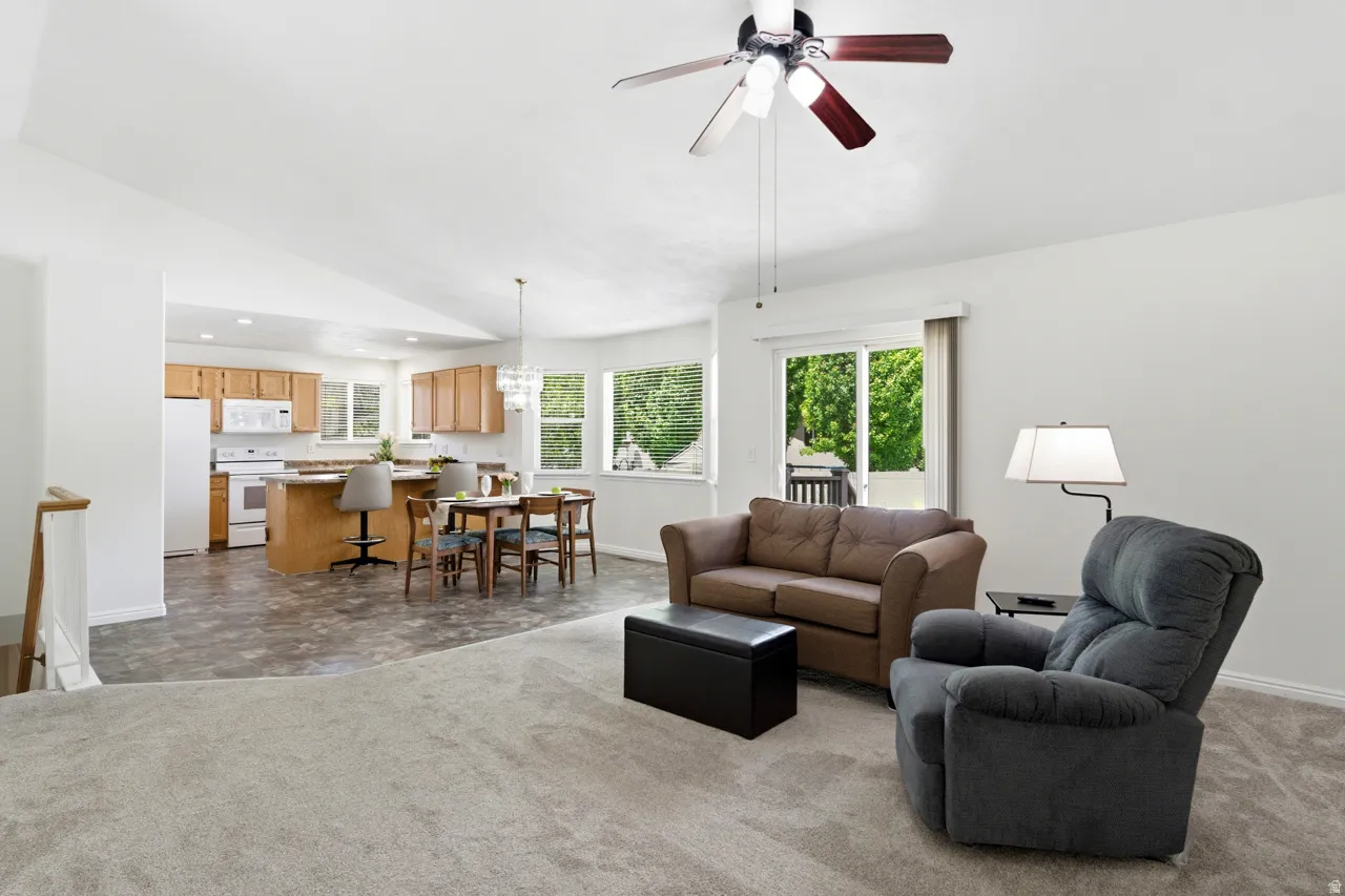 Open-concept living area with vaulted ceiling and ceiling fan