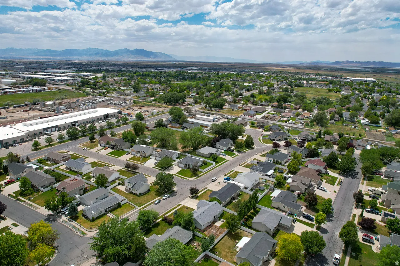 Aerial perspective showcasing a residential neighborhood with single-story homes, mature trees, and paved streets
