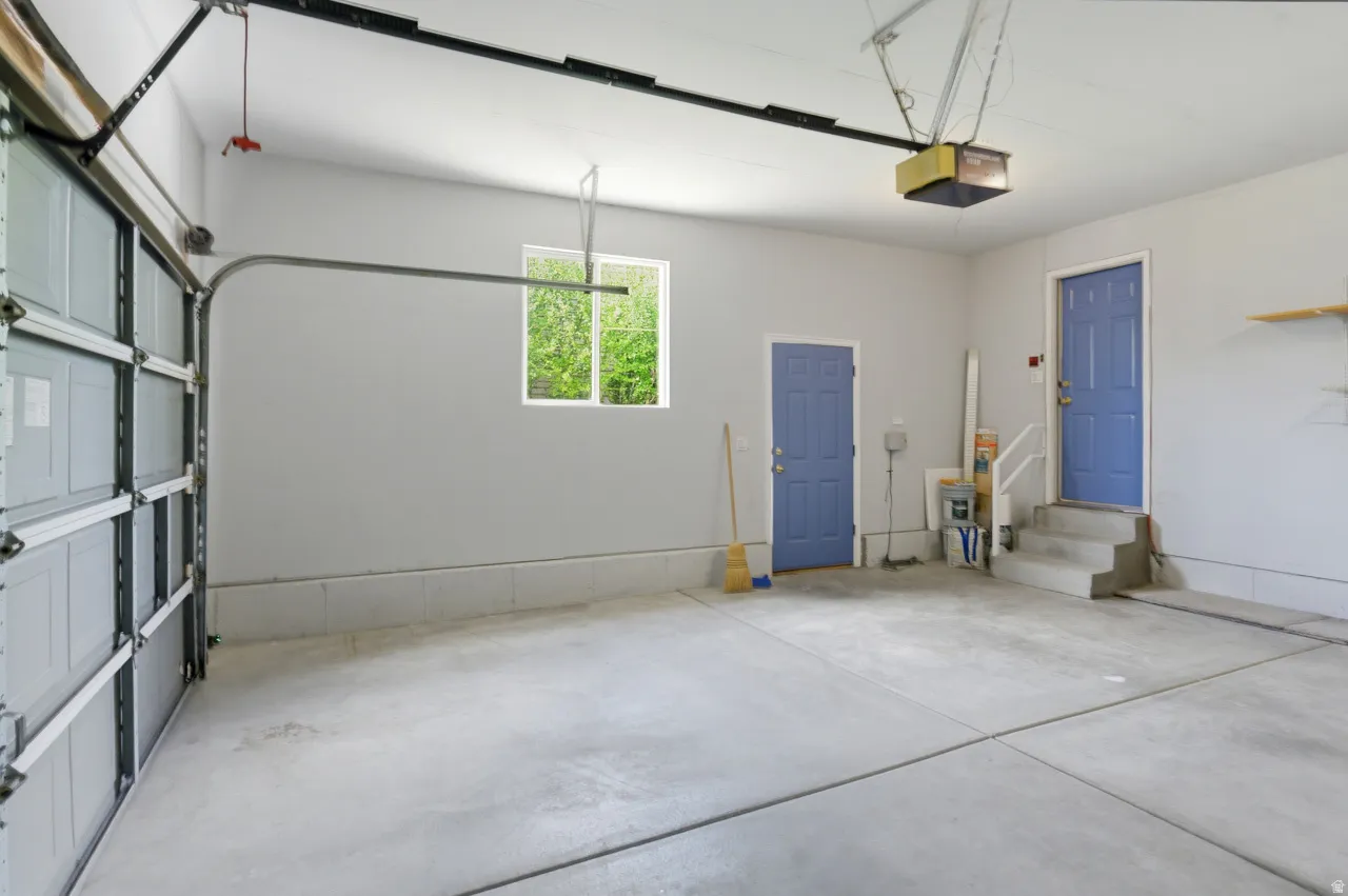 Spacious garage featuring a concrete floor, light gray walls, and an automatic garage door opener