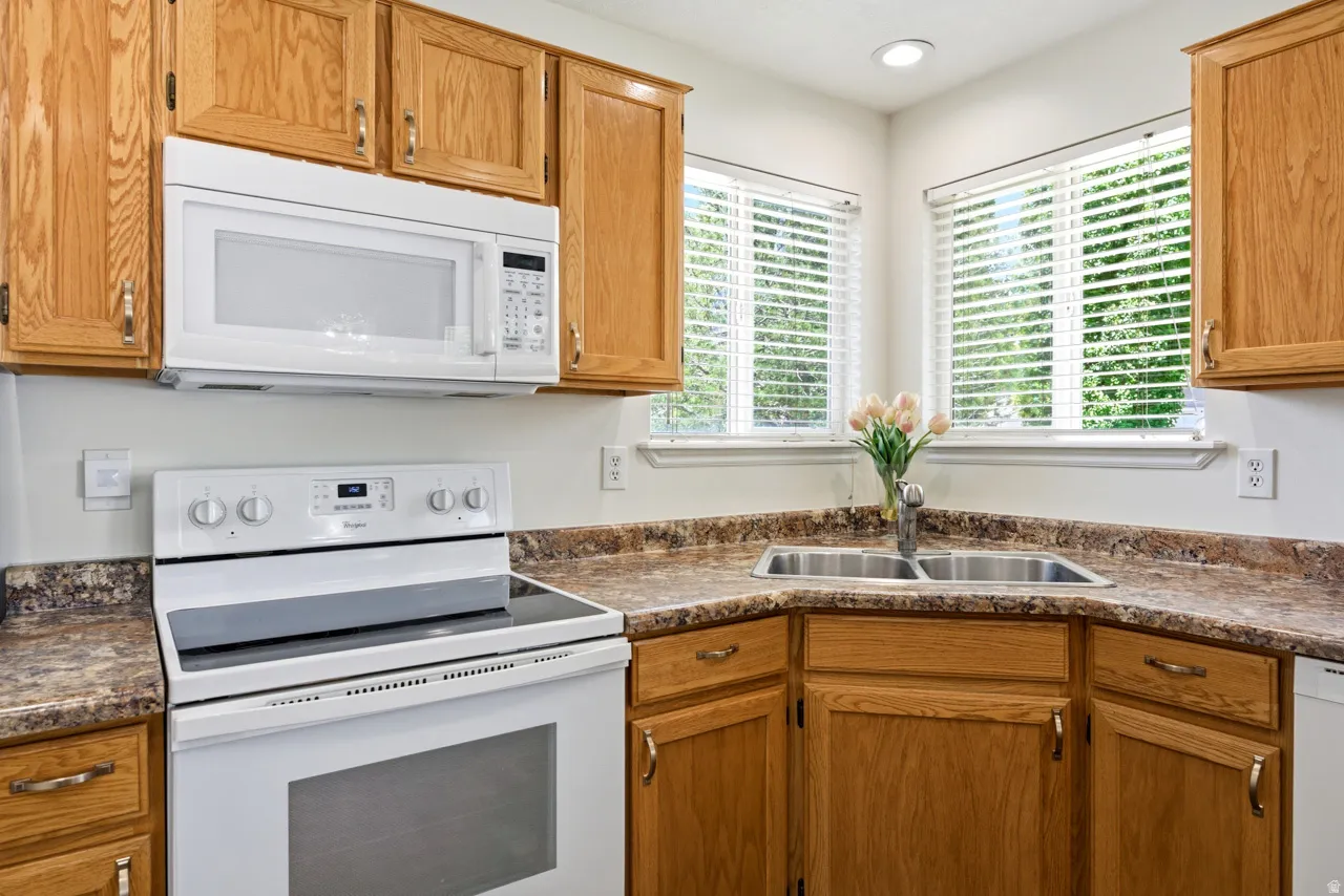 Kitchen featuring light wood cabinetry and stone-look countertops