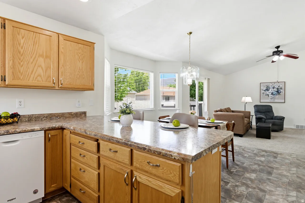 Kitchen featuring light wood cabinetry, a white dishwasher, and a laminate countertop