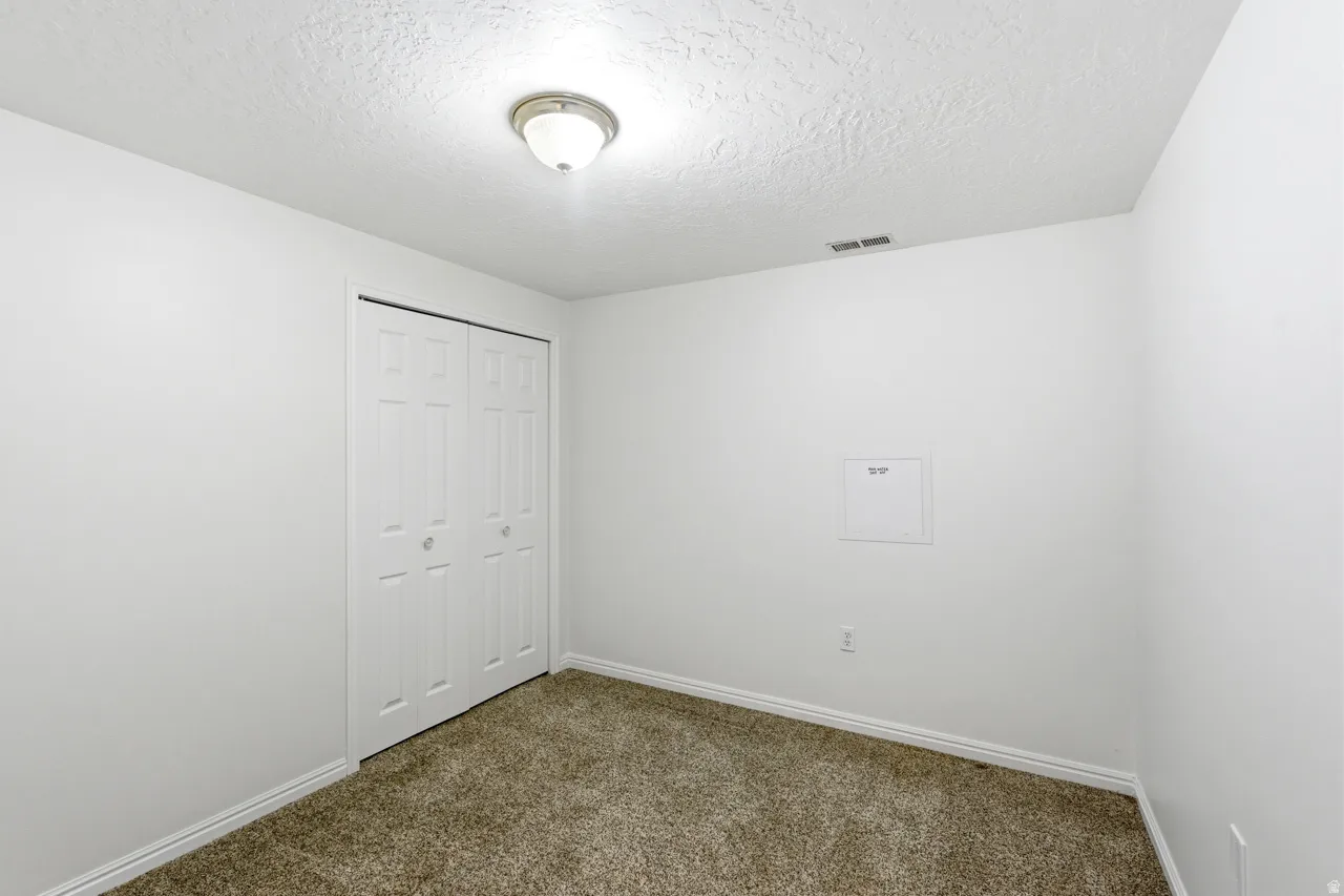 Neutral-toned wall-to-wall carpeting complements the white walls and trim
