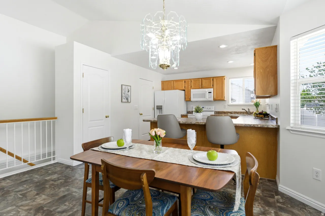 Dining area featuring a decorative chandelier and durable wood-finish flooring