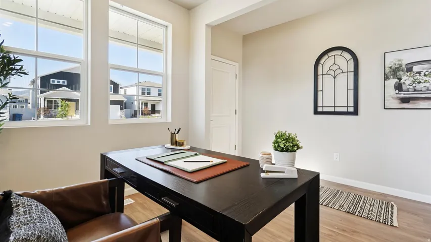 Bright room featuring two large windows, wood-finish flooring, and a solid core door