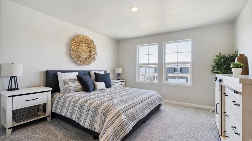 Spacious room featuring light gray wall paint, two large windows, recessed ceiling lighting, and gray carpet flooring