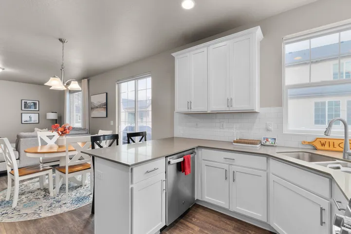 Modern kitchen featuring white shaker-style cabinetry, light-toned countertops, and a white subway tile backsplash
