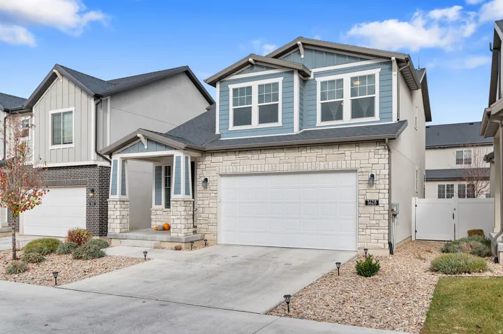 Contemporary residence featuring a stone and siding exterior, an attached two-car garage, and a covered front entry