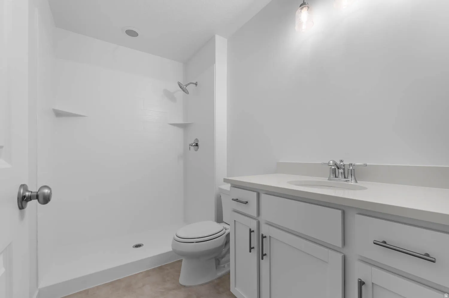 Contemporary bathroom featuring a white vanity with integrated sink, chrome faucet, and coordinating cabinet hardware