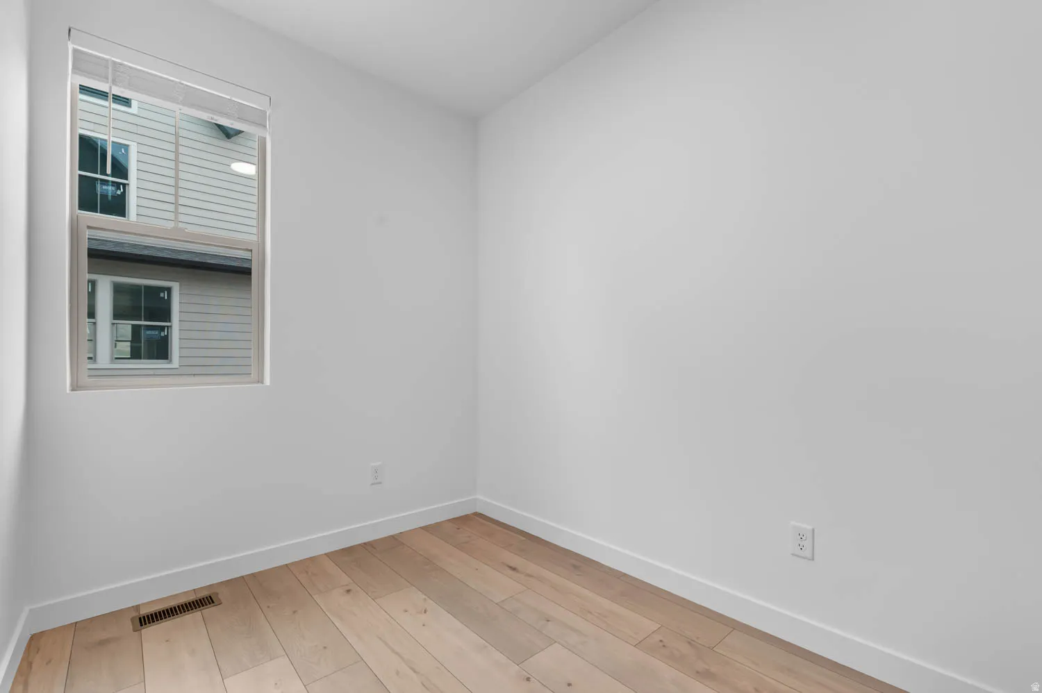 Room featuring light wood-finish flooring, white walls, and white trim