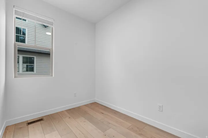 Room featuring light wood-finish flooring, white walls, and white trim