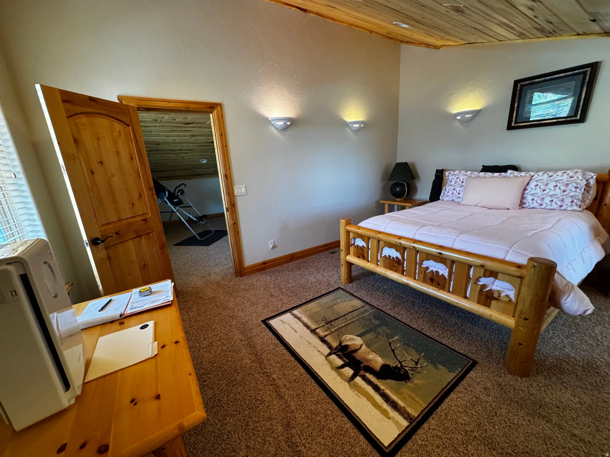 Carpeted room featuring a wood-finish plank ceiling and light-colored walls