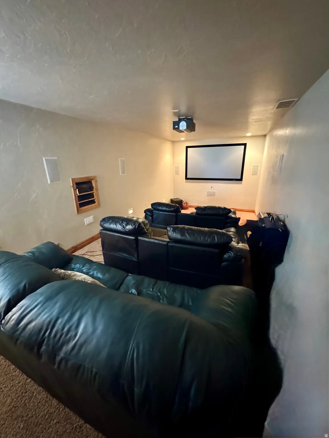 Projector screen with built-in wall speakers and ceiling-mounted projector