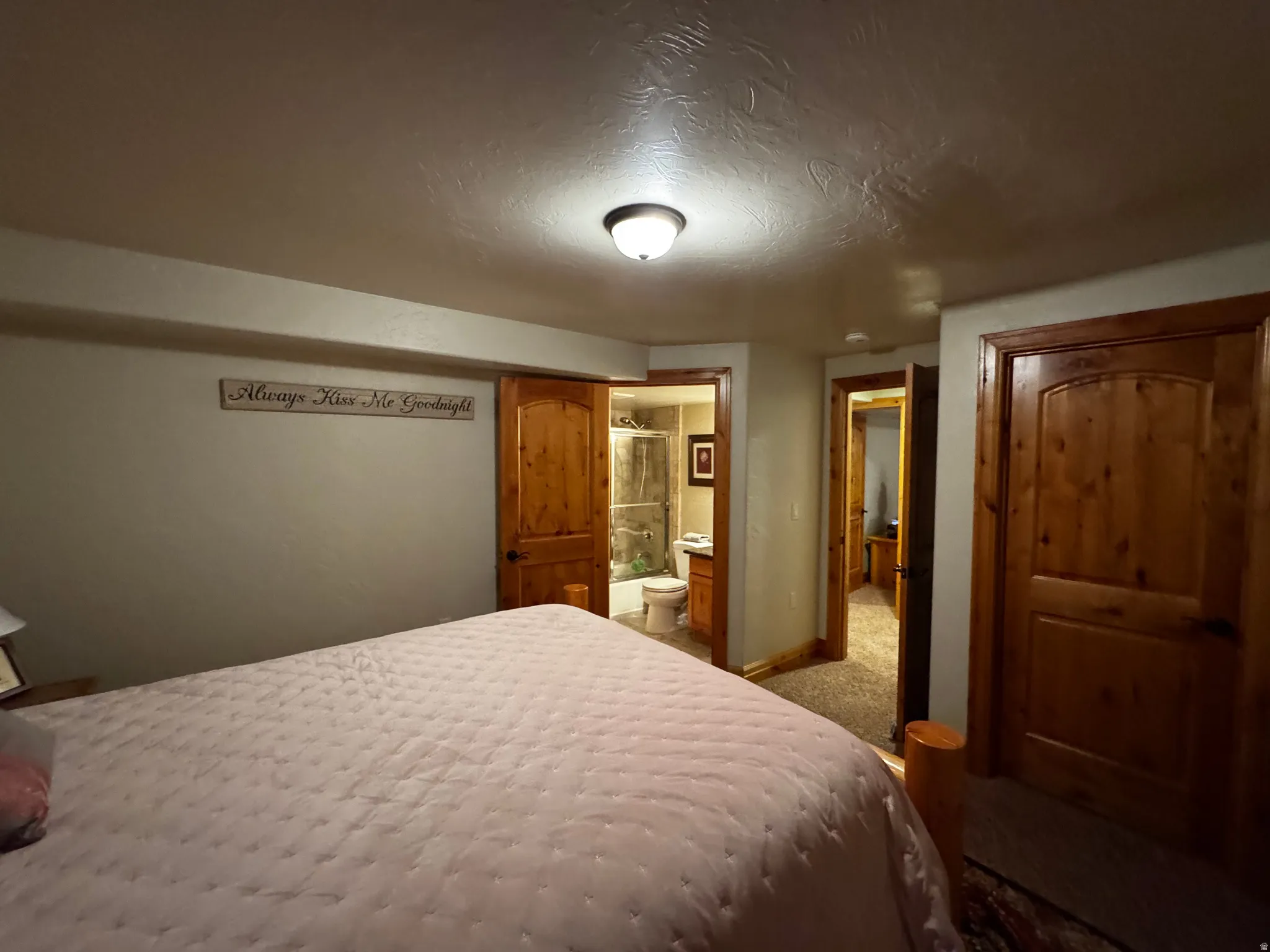 Interior room featuring wood-finish panel doors, a ceiling-mounted light fixture, and textured ceilings