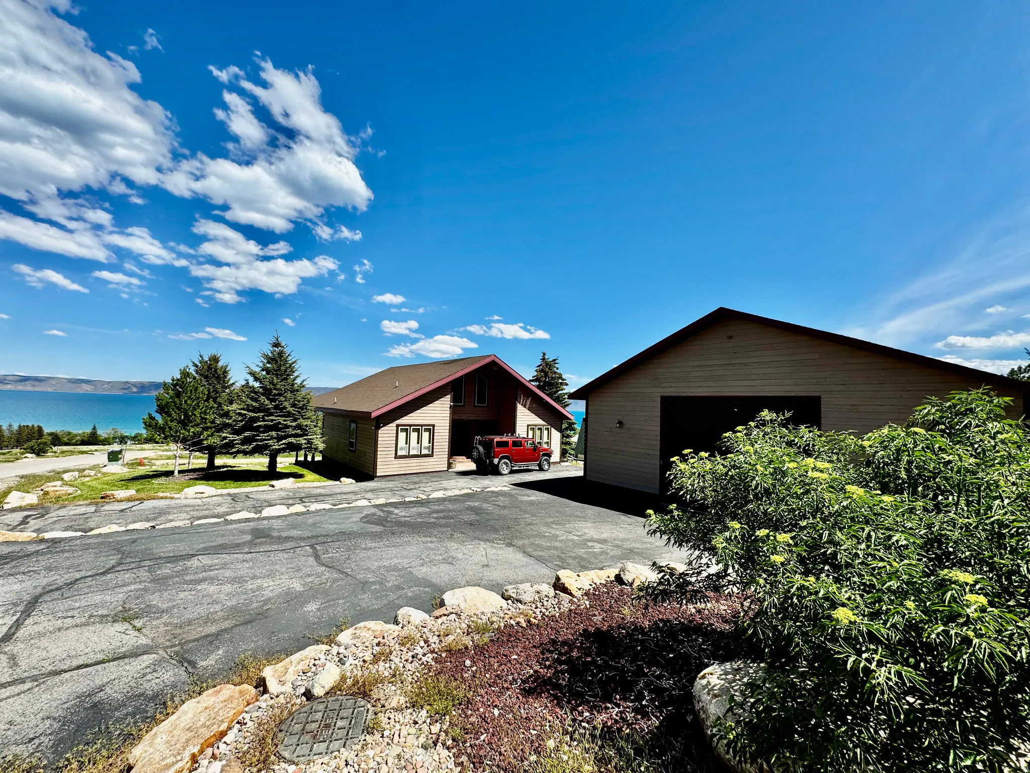 Property featuring a pitched roof, attached garage, and a separate detached garage structure