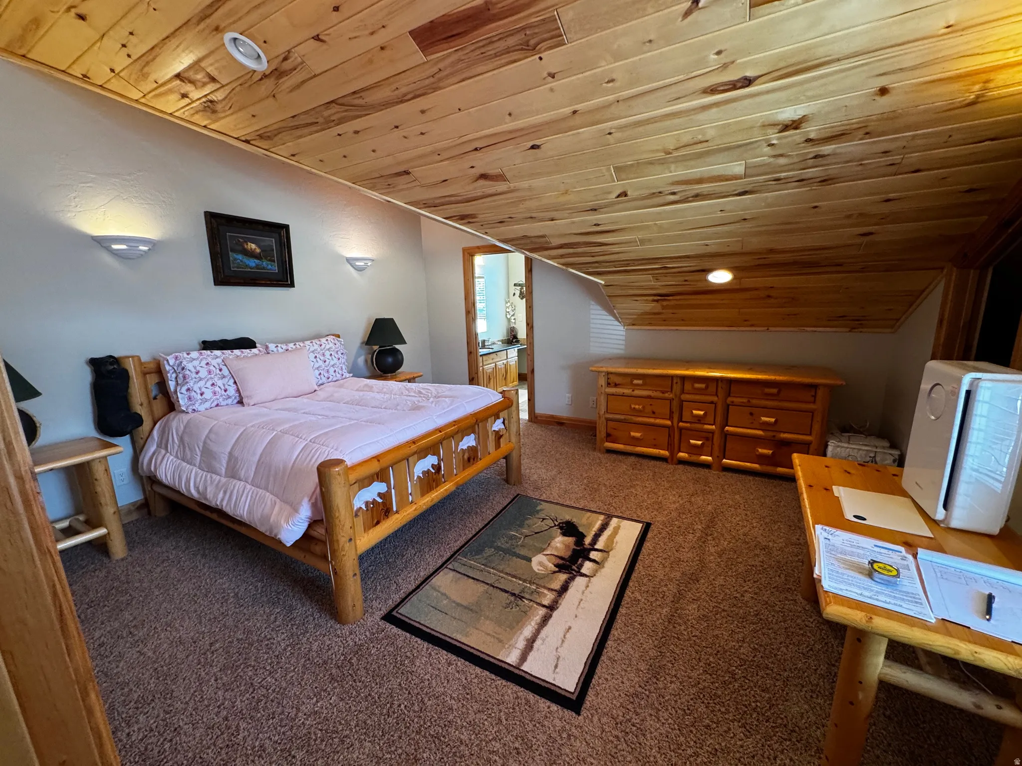 Carpeted room featuring a wood-panel ceiling and sloped walls