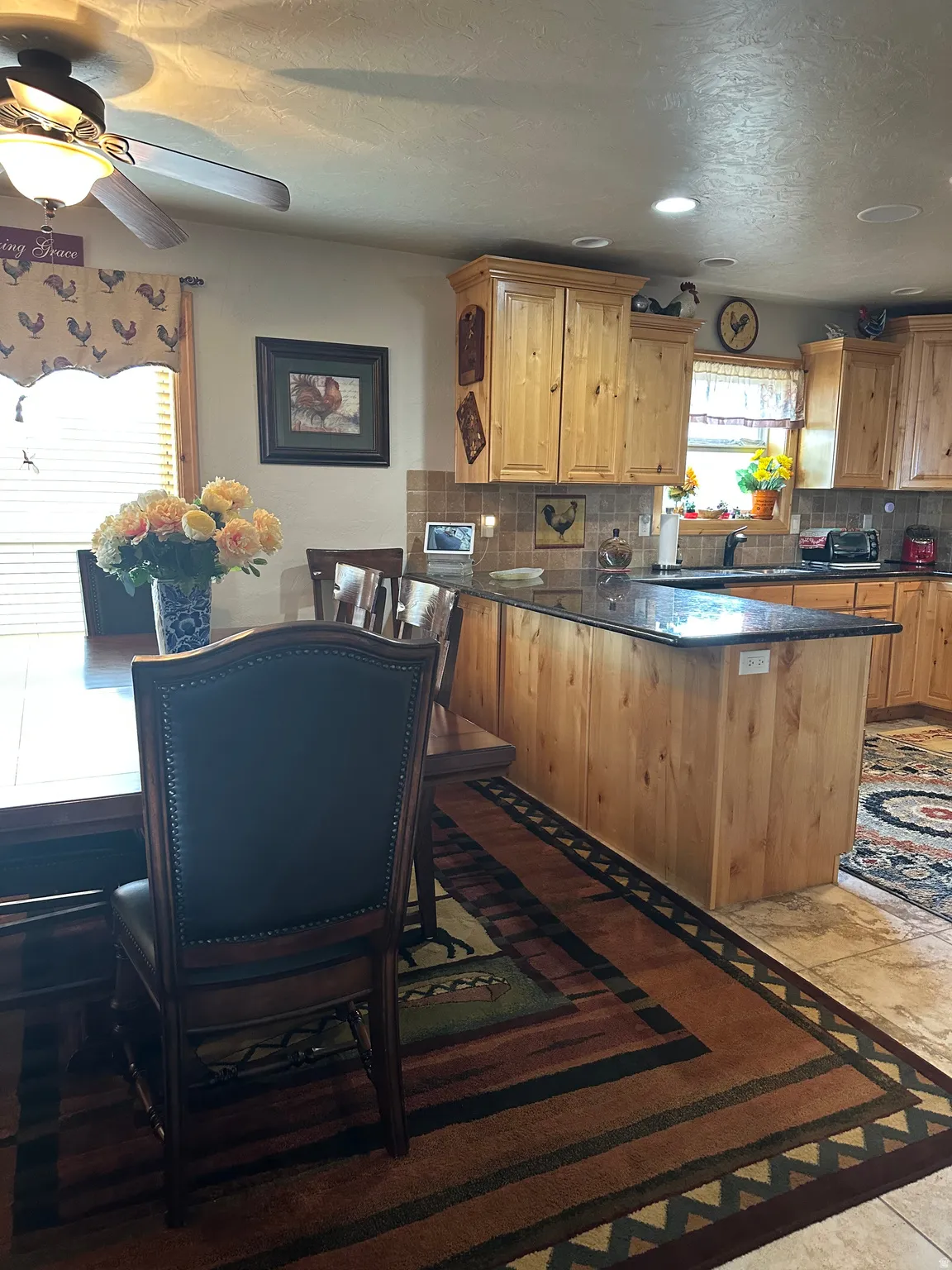 Wood-finish cabinetry, dark granite-style countertops, and tiled backsplash
