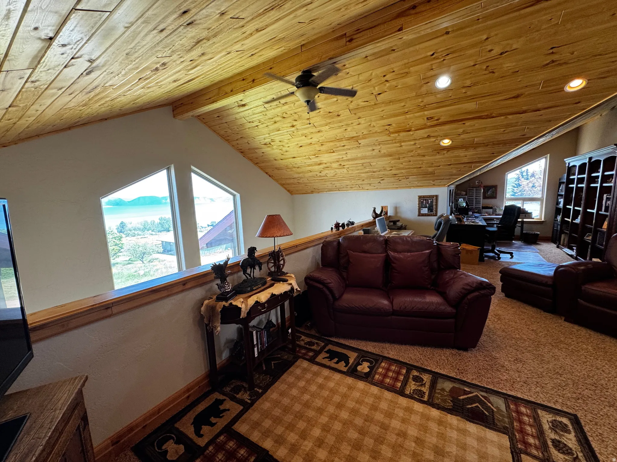 Vaulted wood-paneled ceiling with recessed lighting and ceiling fan