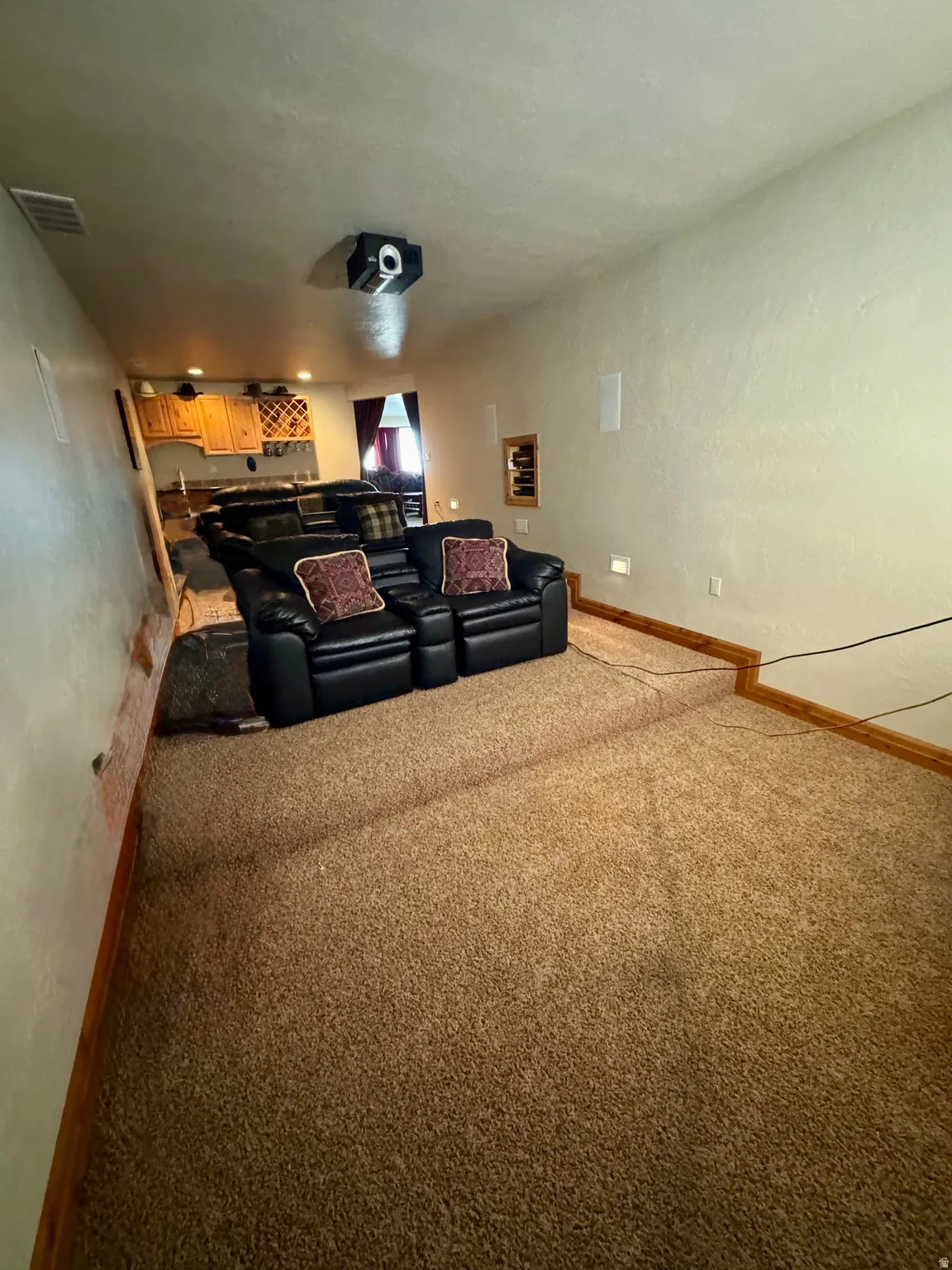 Tiered carpeted flooring with recessed wall lighting and ceiling-mounted projector
