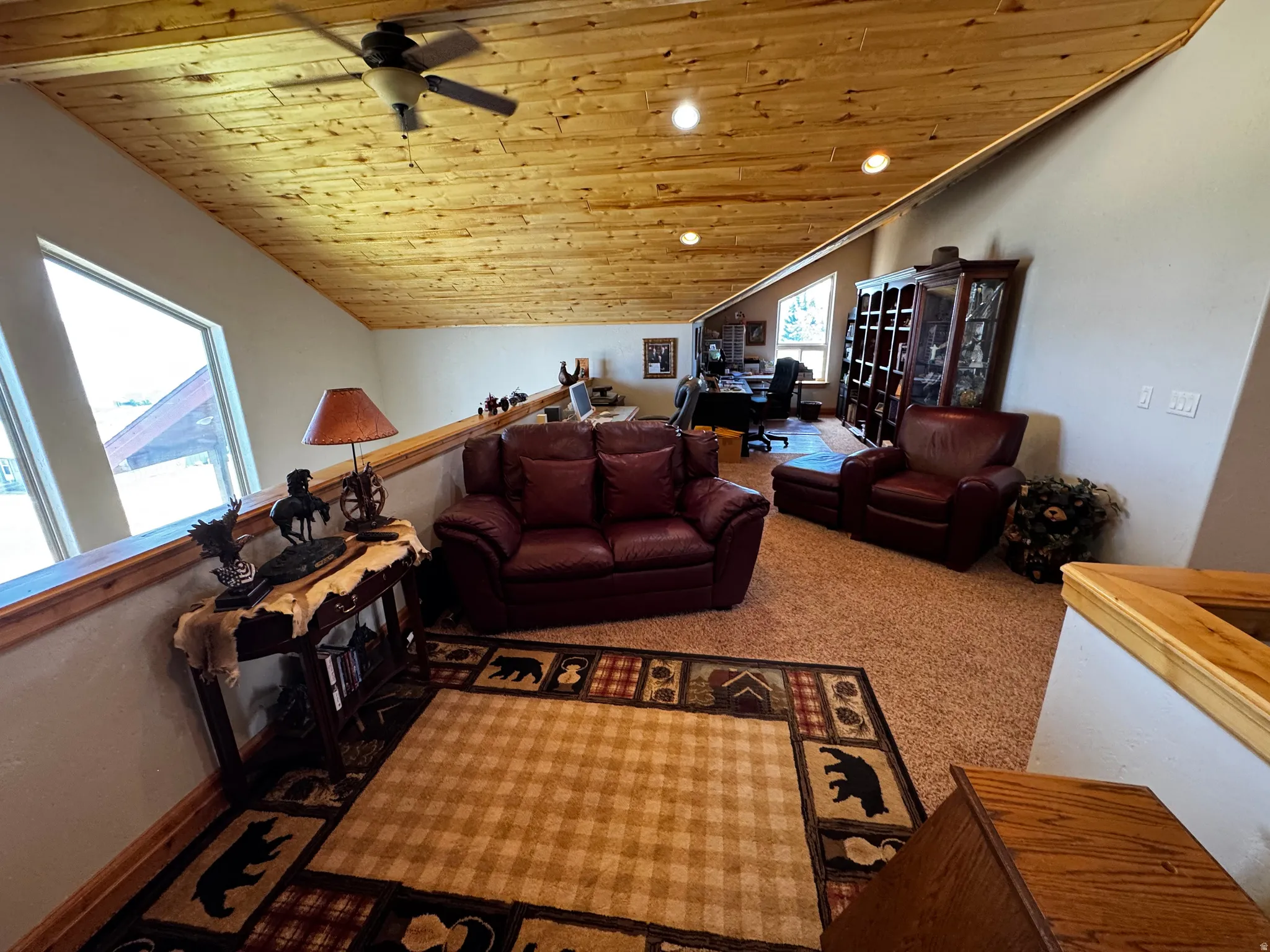 Carpeted loft area featuring a natural wood-finish sloped ceiling, recessed lighting, and a ceiling fan